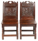 A pair of Charles II oak backstools, Lancashire, circa 1670 Each with a fully-enclosed back having a