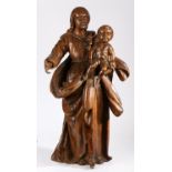 An 18th century walnut figural carving of the Madonna and Child The Virgin wearing flowing robes,