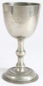 An 18th century pewter communion cup Having a large plain bowl, a flattened-ball knop stem and domed