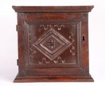 A late 17th century and later oak spice cupboard, Lancashire/Yorkshire The panelled door carved with