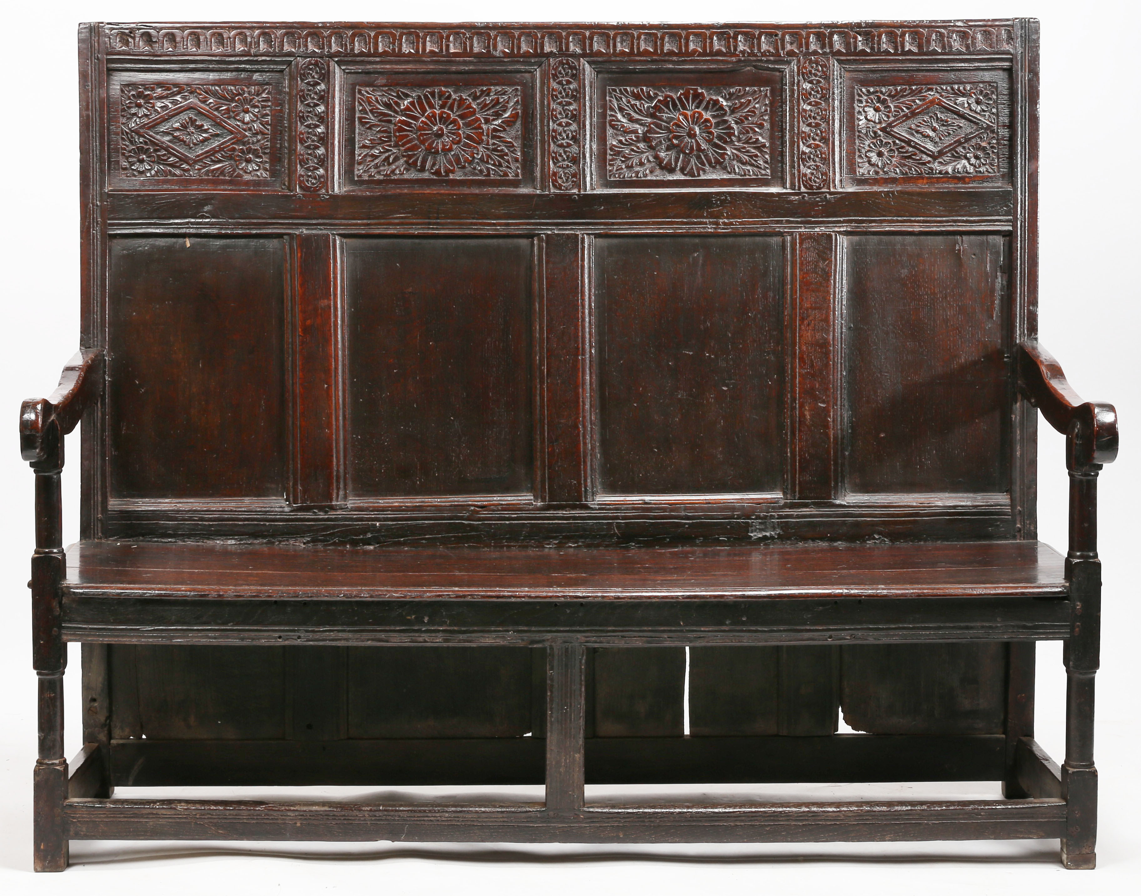 A Charles I oak high-back settle, circa 1640 and later The back with a nulled-carved rail, atop four