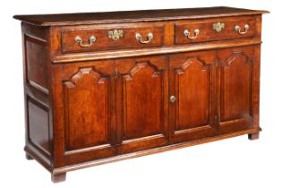 An oak dresser base Parts mid-18th century, having a twin-boarded ovolo-moulded top, over a pair