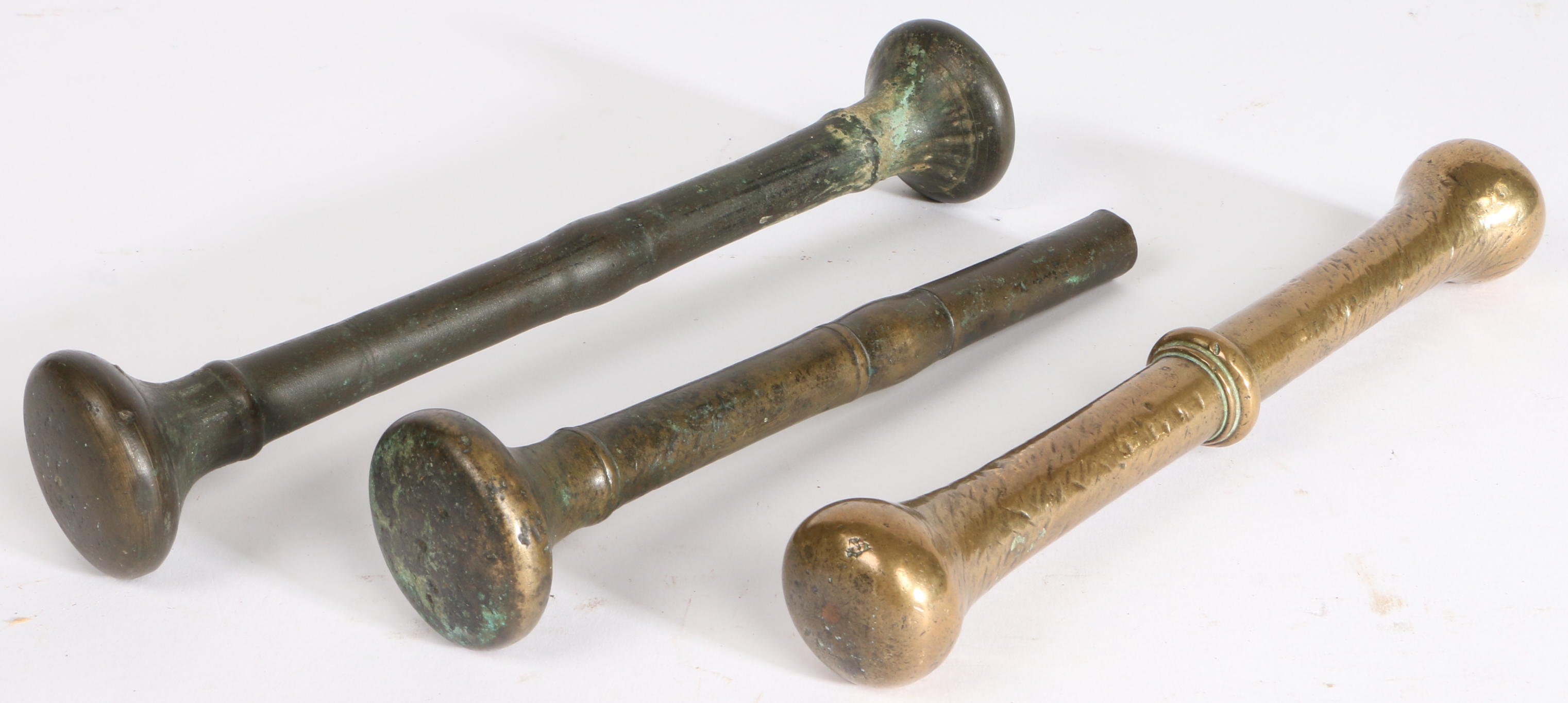 Three 17th/18th century bronze alloy pestles, English Each centred by a fillet, longest 22cm, (3)