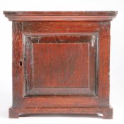 An early 18th century table-top oak spice cupboard, circa 1710-30 Having a fielded panelled cupboard