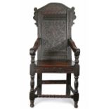 A Charles II oak open armchair, circa 1660 and later The back panel carved with a single flowering