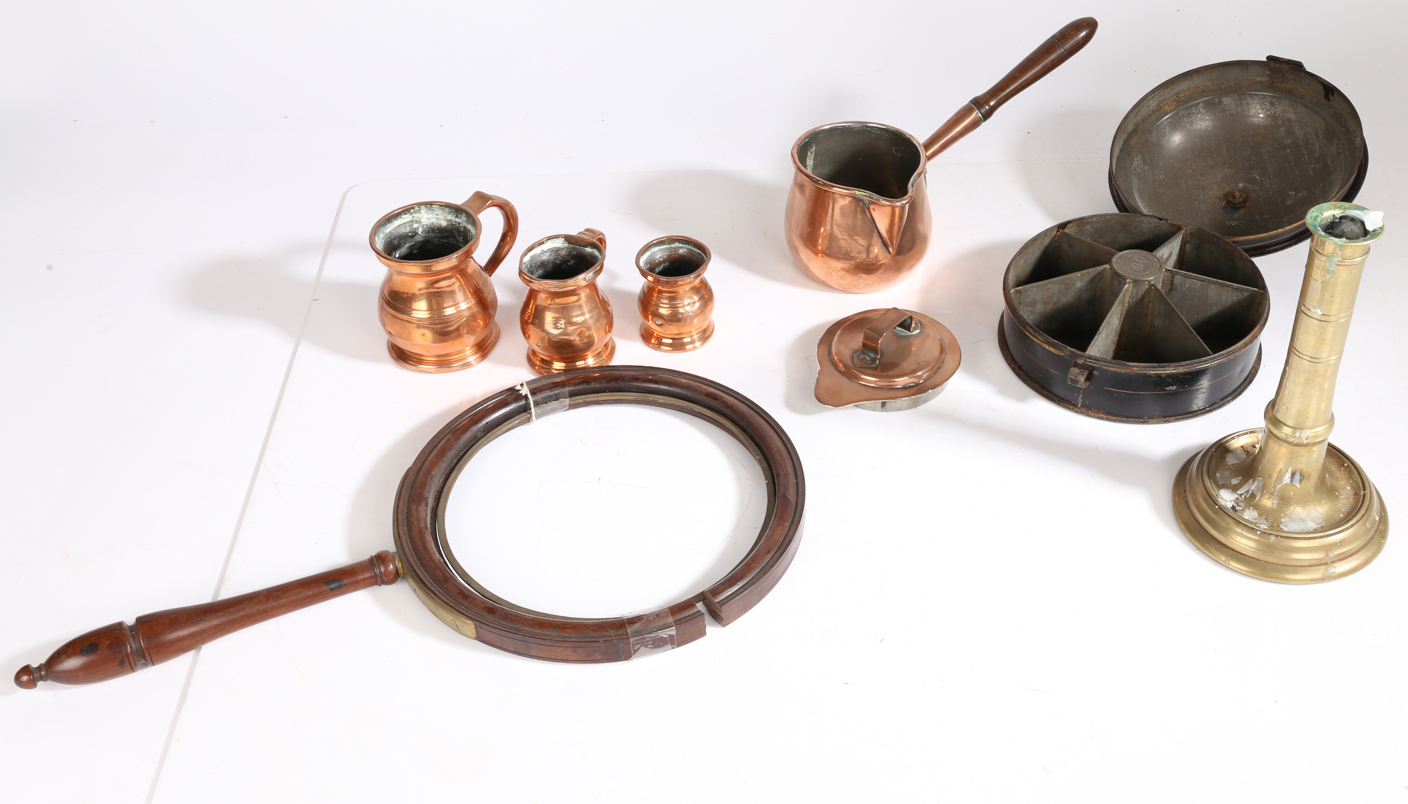 A collection of 19th Century and earlier metalware, to include a candlestick, three copper jugs, a