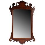 A small George II red walnut wall mirror, the rectangular mirror plate within an arch and swag