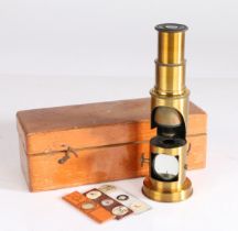 A 20th century cased microscope, together with slides all housed within a wooden case, 18cm wide