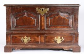 An oak coffer bach, the rectangular top above two fielded arched panels and two short drawers raised