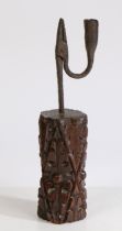 A rush light holder, the iron grip and candle socket above a 16th/17th Century carved section of