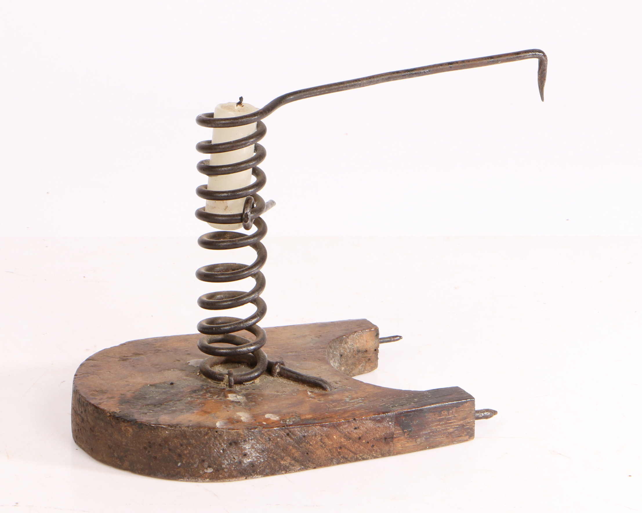 A iron spiral candleholder, the spring shaped holder with curved platform and spikes projecting from