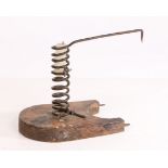 A iron spiral candleholder, the spring shaped holder with curved platform and spikes projecting from