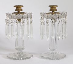 A Pair of Victorian glass table lustres, having a brass candlestick above a cut glass flange with