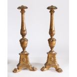 A pair of 19th century Baroque gilt wood lamp bases, having a flared rim above a tapering carved