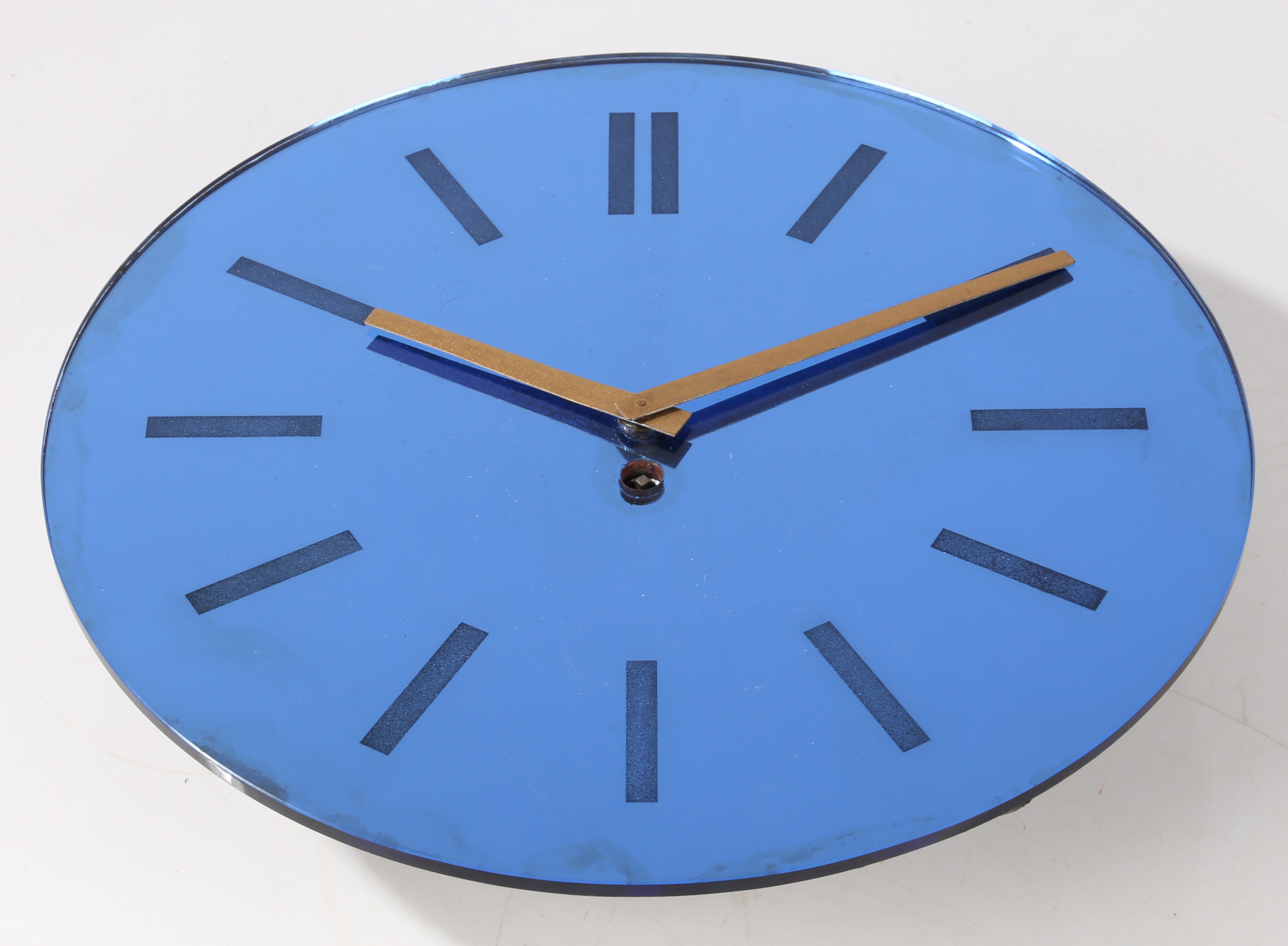 A mid century wall clock, the blue mirrored dial with baton markers and a Garrod movement, 30cm