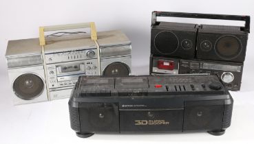 Three portable radio/ cassette players. Toshiba RT-8700S, Hitachi TRK-3D30E, and Sanyo C7s.