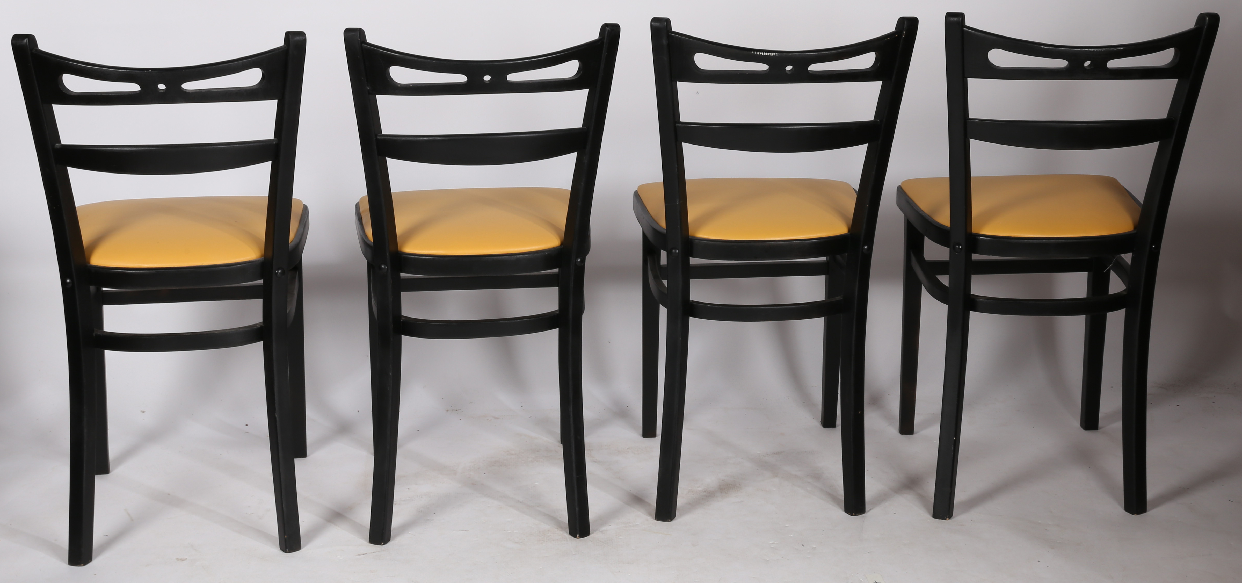 A set of four painted and vinyl upholstered dining chairs in black and tan, stamped to the underside - Image 2 of 4