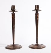 A pair of circa 1930s Bakelite candlesticks of tapering form, raised on round bases, marked to the