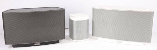 Sonos speakers. Two Play: 5 speakers, one black and one white, together with a Play: 1 in white. (