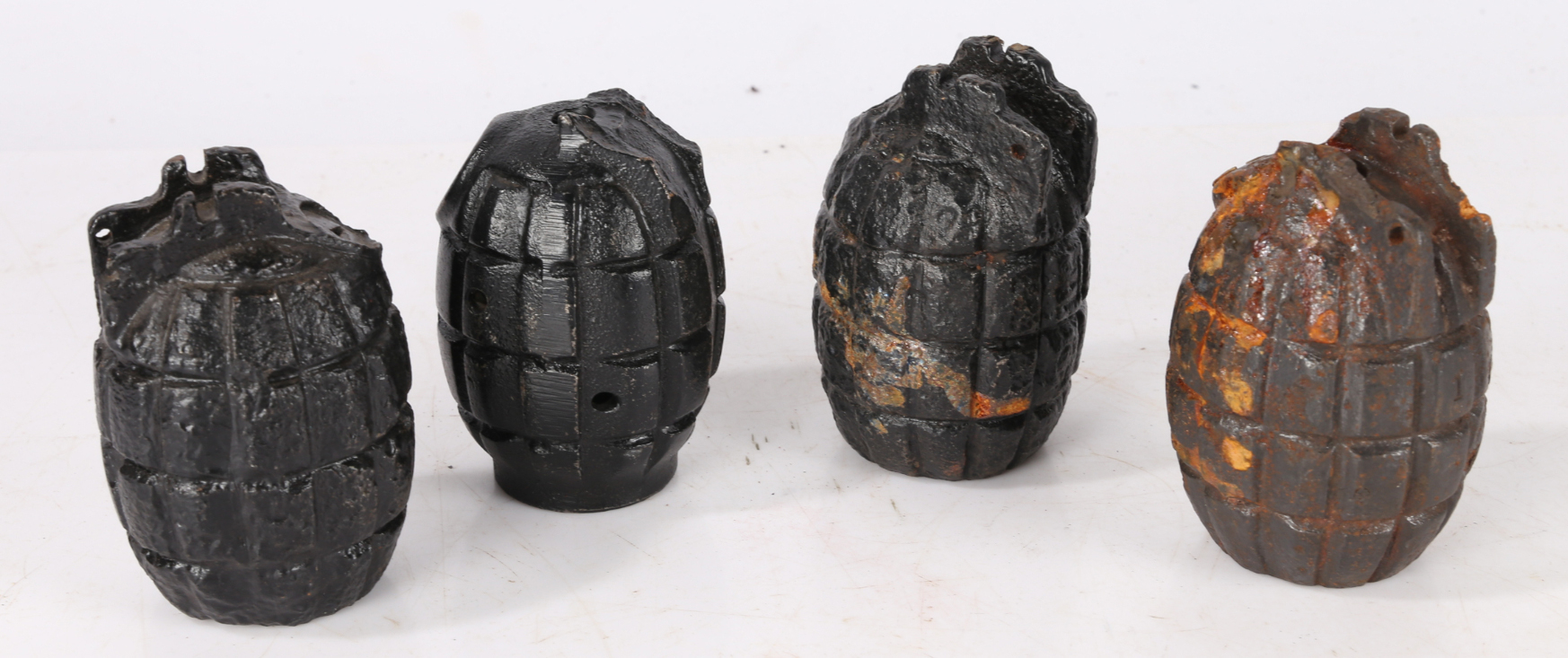 Four First World War British Mills Grenade casings, no safety levers, pins or base plugs, inert, (
