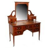 An Edwardian mahogany, satinwood and boxwood strung dressing table, the shaped bevelled mirror