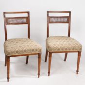 A pair of Regency mahogany side chairs with caned splats and stuff over upholstered seats, raised on