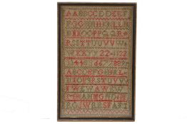 A Victorian needlework sampler, embroidered with the alphabet, housed in an ebonised and glazed