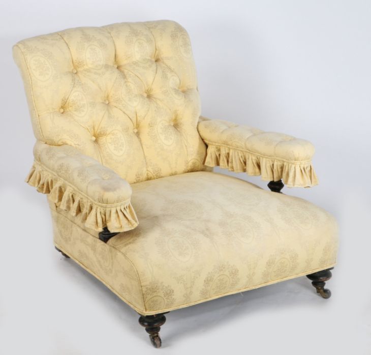 A Victorian fully upholstered low armchair, in the Howard and Sons style, upholstered in a yellow