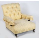 A Victorian fully upholstered low armchair, in the Howard and Sons style, upholstered in a yellow