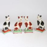 Two pairs of 19th century Staffordshire pottery cats, one pair in black, the other in ginger, all