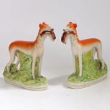 A pair of Staffordshire greyhounds, each with hares to the mouth, 28cm tall (2)