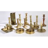 A collection of 19th century and later brass candlesticks, chambersticks and a wall mounted