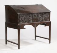 A late 17th Century desk box, the foliate and scroll carved front dated 1699, the sloping lid