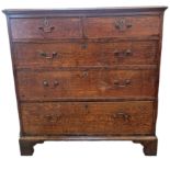 A George III oak chest of two short and three long drawers, with brass swan neck handles, raised