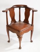 A George II walnut corner chair, the shaped cresting rail above two vase form splat backs, the