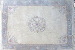 A large 20th century Chinese wool rug, set with a central floral medallion together with a Greek key