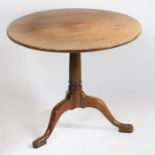 A George III oak occasional table, the circular tilt-top above a turned stem, tripod legs and