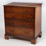 A George III mahogany commode, modelled as a chest of four long drawers, the hinged lid opening to