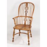 An 18th Century ash and elm elbow chair, probably East Anglian, the arched back with turned spindles