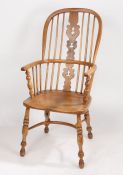 An 18th Century ash and elm elbow chair, probably East Anglian, the arched back with turned spindles