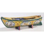 A Faience pottery boat, the hull painted with animals on a yellow ground, some damage, 35.5cm long