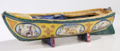 A Faience pottery boat, the hull painted with animals on a yellow ground, some damage, 35.5cm long