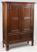 An 18th Century oak standing cupboard, the swept pediment above two panelled cupboard doors