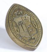 A brass seal matrix, of navette form, the central field engraved with a coat of arms and inscribed