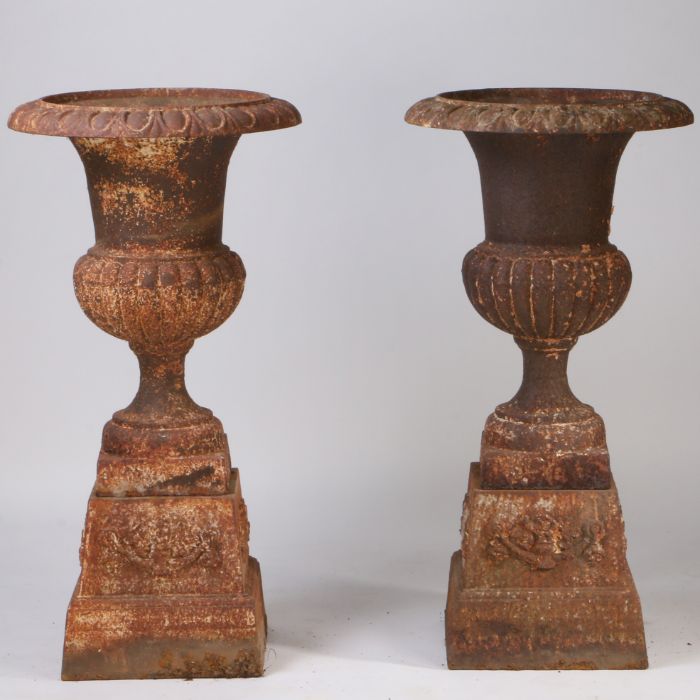 A Large pair of 19th century cast iron garden urns, having a fluted top above a gadrooned body set