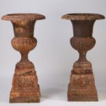 A Large pair of 19th century cast iron garden urns, having a fluted top above a gadrooned body set