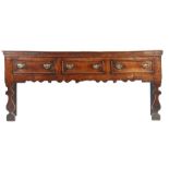 A George I oak and elm low dresser, circa 1720 Having a boarded top with applied moulded under-edge,