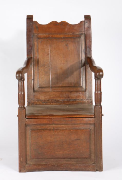 An oak and walnut box-seat open armchair, circa 1700 Having a fielded and moulded plain back