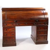 A 19th century mahogany roll top desk, the roll top opening to reveal five birds eye maple drawers
