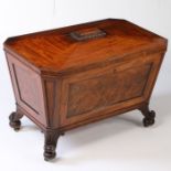 A George III mahogany cellarette or wine cooler of sarcophagus form, the angled top above paneled